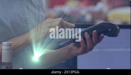 Image de taches lumineuses sur une femme caucasienne payant avec carte de crédit Banque D'Images