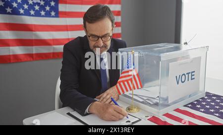 Homme d'âge moyen votant dans une élection américaine à l'intérieur avec un drapeau américain en toile de fond. Banque D'Images