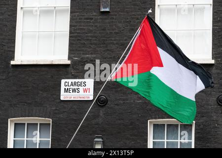 Londres, Royaume-Uni. 15 avril 2024. Un drapeau palestinien flotte à Clarges Mews alors que les bureaux de London Metric Property sont bloqués par des activistes de Londres pour Une Palestine libre et Sisters Uncut. La société loue des biens à des fabricants d'armes, notamment Elbit Systems d'Israël, la société britannique BAE et l'américain Boeing. Les activistes ont exigé que London Metric abandonne ses contrats avec les fabricants d'armes et pour un embargo militaire contre Israël. La manifestation faisait partie d'une « action A15 » multi-villes. Crédit : Ron Fassbender/Alamy Live News Banque D'Images