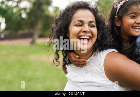 Bonne mère indienne s'amuser avec sa fille à l'extérieur - famille, fête de maman et concept d'amour - Focus sur le visage de maman Banque D'Images