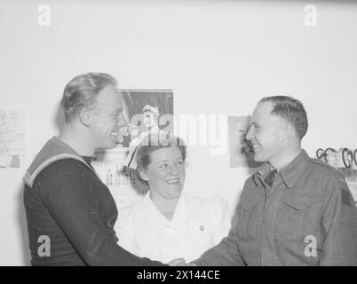 À L'ÉCOLE DES ARTILLEURS TÉLÉGRAPHISTES DE LA ROYAL NAVY AU CANADA. FÉVRIER 1945, YARMOUTH (NOUVELLE-ÉCOSSE). - Le soldat William Cook, de l'Armée canadienne, remercie NA1 Walker, de Leeds, et NA1 Irvine, de Maidenhead, pour leurs dons de sang qui ont peut-être aidé à sauver sa vie alors qu'ils étaient en service actif en Belgique Banque D'Images