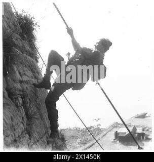 LIFE AT COASTAL DEFENCE BATTERIES - Cliff Scaling fait partie du programme d'une des batteries et aide à maintenir les hommes dans un parfait état de forme physique. Diverses armes sont portées par les hommes pendant l'escalade British Army Banque D'Images