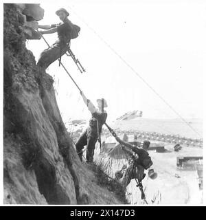 LIFE AT COASTAL DEFENCE BATTERIES - Cliff Scaling fait partie du programme d'une des batteries et aide à maintenir les hommes dans un parfait état de forme physique. Diverses armes sont portées par les hommes pendant l'escalade British Army Banque D'Images