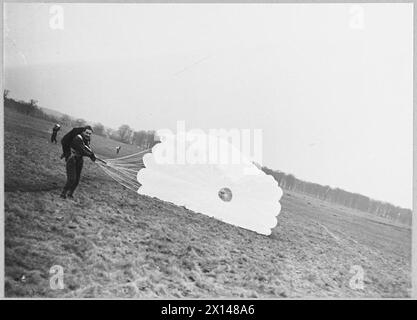 PARACHUTISTES BRITANNIQUES : LE SERVICE PREND À LA SOIE - une fois débarqué, les parachutistes rassemblent sa chute Royal Air Force Banque D'Images