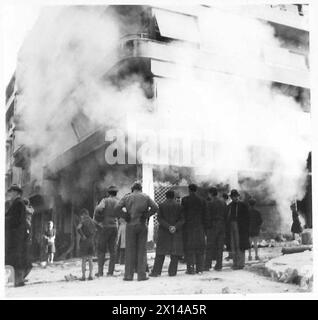 GRÈCE : LES COMBATS D'ATHÈNES SE TERMINENT - Une zone dévastée près de la place Omonia dans laquelle les bâtiments brûlent encore. Maintenant que la zone a été nettoyée, les gens viennent dans les rues pour regarder l'armée britannique Banque D'Images