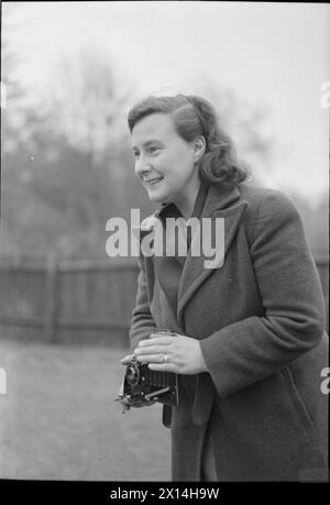 YMCA SNAPSHOTS FROM HOME : CIVILIAN PHOTOGRAPHERS AT WORK, UK, 1944 - Un portrait de la photographe amateur souriante Mme Lorna nickel alors qu'elle prend une photo dans le jardin d'une maison à Harrow Weald Banque D'Images