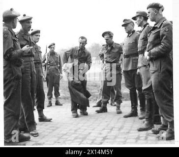 LES TROUPES QUI AVANCENT atteignent CELLE - officiers britanniques interrogeant les Allemands. Un ex-prisonnier russe écoute British Army, 21st Army Group Banque D'Images