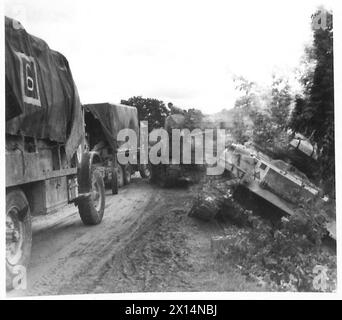 HUITIÈME ARMÉE : LA PLUIE RALENTIT L'AVANCE - sur les routes dangereuses les conducteurs avaient peu de contrôle sur leurs véhicules. Ce char a glissé au bord de la route, qui a cédé la place, amenant le char. Les camions de 3 tonnes franchissent soigneusement le fossé A.F.V British Army Banque D'Images