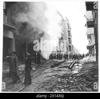 GRÈCE : LES COMBATS D'ATHÈNES SE TERMINENT - Une zone dévastée près de la place Omonia dans laquelle les bâtiments brûlent encore. Maintenant que la zone a été nettoyée, les gens viennent dans les rues pour regarder l'armée britannique Banque D'Images