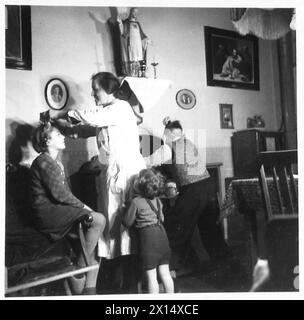 LES ENFANTS HOLLANDAIS VONT EN ANGLETERRE POUR RÉCUPÉRER - Une mère attache l'arc dans les cheveux de sa fille tandis que le fils se peigne les cheveux avant de commencer leur voyage vers l'Angleterre British Army, 21st Army Group Banque D'Images