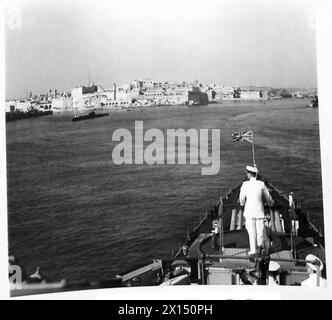 Sa Majesté le Roi se tenait sur le pont du croiseur Aurora alors qu'il entrait dans le Grand Port de la Valette, répondant aux acclamations du peuple maltais. Banque D'Images