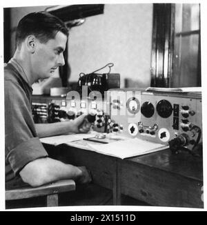 SERVICE DE RADIODIFFUSION DES FORCES BRITANNIQUES À HAMBOURG 1945 - le caporal Joe Robinson, REME surveille la sortie du studio à BFN Hambourg BFN Hambourg Banque D'Images