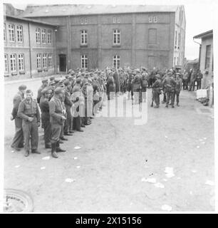 La 5e DIVISION AVANCE DE L'ELBE VERS LUBECK - après avoir remis des fusils, etc., ils se sont formés sur la place de la caserne, attendant d'être emmenés à la P.O.W. cages British Army, 21st Army Group Banque D'Images