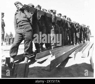 Le personnel de la Palestine Pioneer Company porte une poutre à charger sur un train pendant les opérations dans le désert occidental. Banque D'Images