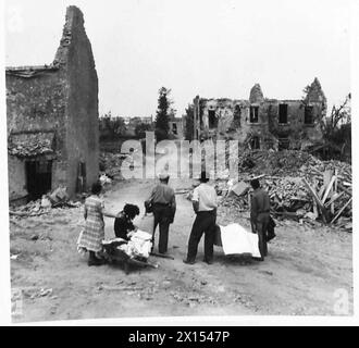 Une FAMILLE FRANÇAISE RETOURNE À LEUR VILLAGE DÉCHIRÉ D'OBUS - comme ils arrivent dans le village, ils voient pour la première fois la rue du village British Army, 21st Army Group Banque D'Images