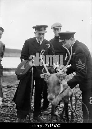 RENNES PRÉSENTÉS À ADMIRAL WELLS (ACOS). DÉCEMBRE 1943, SCAPA FLOW. L'AMIRAL WELLS, COMMANDANT DES ORCADES ET DES SHETLANDS, A REÇU 'OLGA', UN RENNE DE 3 MOIS, COMME CADEAU DE NOËL DE L'AMIRAL GOLOVKO, COMMANDANT EN CHEF DE LA FLOTTE DU NORD, AUX AUTORITÉS NAVALES BRITANNIQUES À SCAPA FLOW. OLGA A FAIT LE VOYAGE DEPUIS LA RUSSIE À BORD D'UN CROISEUR BRITANNIQUE FAISANT UNE COURSE DE ROUTINE VERS LE SUD. - L'amiral Sir Lionel Wells admirant Olga à son arrivée Banque D'Images