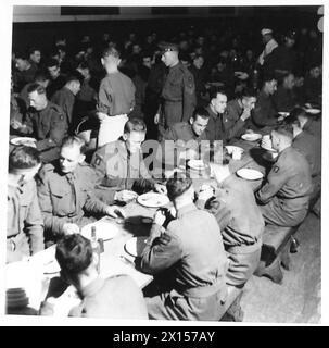 Les membres d'un bataillon de la Garde écossaise s'assoient pour un repas dans la salle à manger lors d'une visite de l'armée britannique, reflétant les routines quotidiennes du personnel militaire. Banque D'Images