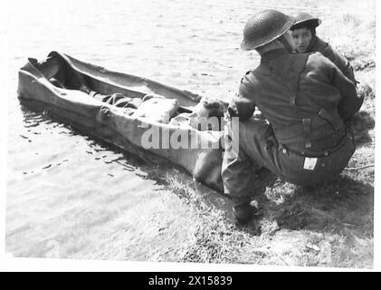 LE CORPS MÉDICAL ADOPTE DES MÉTHODES COMMANDO - le brancard et le patient sont tirés sur la rive de la rivière British Army Banque D'Images