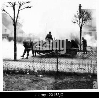 Des correspondants de guerre visitent le Eastern Command où un véhicule blindé ennemi est arrêté par des défenses en fil barbelé et des bombes incendiaires sous le contrôle de l'armée britannique. Banque D'Images