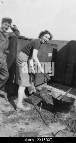Helen Ormiston pelle du charbon avec Jock Hazell à North Witham, en septembre 1944, tout en servant avec la Croix-Rouge américaine en Grande-Bretagne. Banque D'Images