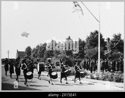 Air Officer Commanding inspecte les opérateurs de ballons W.A.A.F. alors que le groupe de trompettes W.A.A.F. passe devant lors d'un événement de la Royal Air Force. Banque D'Images
