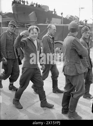 LIBÉRATION DE L'EUROPE : LES PRISONNIERS ALLEMANDS ARRIVENT EN ANGLETERRE DE NORMANDIE. 12 JUIN 1944, QUAIS DE SOUTHAMPTON. PRISONNIERS ALLEMANDS, SOLDATS, MARINS, AVIATEURS ET CIVILS ARRIVANT DE FRANCE DANS LES PORTS BRITANNIQUES. - Un jeune prisonnier de guerre allemand semble heureux d'en être sorti Banque D'Images