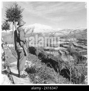 ITALIE : CINQUIÈME SECTEUR ARMYAMERICAN - DVR. C.A. Langford, RASC., de Boston, Lines, regarde au-dessus des sommets enneigés du secteur tenu par les Américains sur le front de la Cinquième armée British Army Banque D'Images