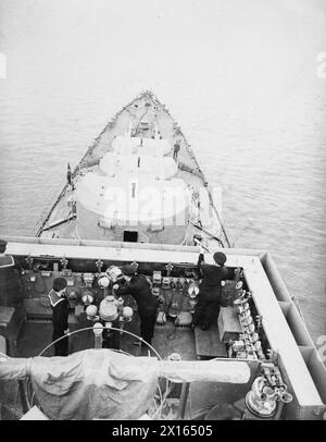 Le HMS Bonaventure, un croiseur léger de classe Dido, est représenté en 1940 avec des tourelles de canon visibles de 5,25 pouces et le pont du navire au premier plan. Banque D'Images