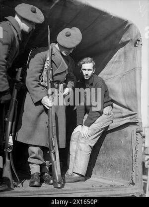 LA CORVETTE FRANÇAISE COULE 2 U-BOOTS. LE 14 MARS 1943, GREENOCK, LE COMBATTANT FRANÇAIS CORVETTE ACONIT COULE DEUX U-BOOTS PAR GUNFIRE ET PERCUTANT TOUT EN ESCORTANT UN CONVOI DE L'ATLANTIQUE À TRAVERS UN PACK DE U-BOOT LE 10 MARS 1943. LE DEUXIÈME SOUS-MARIN VENAIT DE TORPILLER LE DESTROYER BRITANNIQUE HMS HARVESTER. L'ACONIT SE DIRIGEA VERS UN PORT BRITANNIQUE AVEC DES SURVIVANTS DE LA RÉCOLTEUSE ET UN MARCHAND, ET DES PRISONNIERS DES DEUX SOUS-MARINS. - Un prisonnier allemand sous-marin pris en charge par les FFS ACONIT partant pour un camp de prisonniers dans un camion escorté Banque D'Images