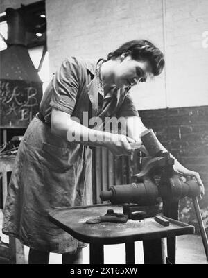 FORMATION POUR LE TRAVAIL DE GUERRE AU CENTRE DE FORMATION DU MINISTÈRE DU TRAVAIL DE CHELSEA POLYTECHNIC, LONDRES, ANGLETERRE, 1941 - Une stagiaire dans l'atelier d'essayage du Centre de formation du Ministère du travail de Chelsea Polytechnic plie la tôle dans le cadre de sa formation Banque D'Images