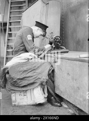 Le signaleur May à bord du HMS Repulse répare les drapeaux lors du radeau du navire en cale sèche en 1940. Banque D'Images