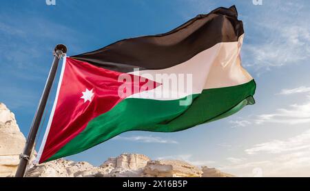 Die Fahne von Jordanien flattert im Wind, isoliert gegen blauer Himmel Banque D'Images