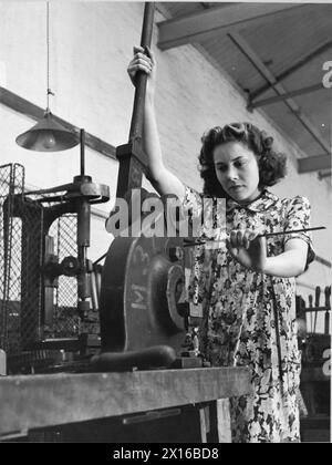 FORMATION POUR LE TRAVAIL DE GUERRE AU CENTRE DE FORMATION DU MINISTÈRE DU TRAVAIL DE CHELSEA POLYTECHNIC, LONDRES, ANGLETERRE, 1941 - Un stagiaire dans l'atelier d'essayage du Centre de formation du Ministère du travail de Chelsea Polytechnic perce un trou dans une barre de métal Banque D'Images