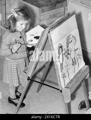 COLONIE POUR ARTISTES DE MOINS DE SIX ANS : ÉVACUÉS À DARTINGTON HALL, TOTNES, DEVON, ANGLETERRE, 1941. - Doreen Hogwood, âgée de 6 ans, évacuée de Gravesend dans le Kent, se concentre sur la peinture sur laquelle elle travaille au Dartington Hall à Totnes, Devon. De l'autre côté du chevalet sur lequel elle travaille, on peut voir une autre peinture Banque D'Images