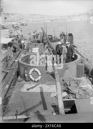 LES PETITS NAVIRES ALLEMANDS SE RENDENT. MAI 1945, ANCÔNE, ITALIE. DIVERS PETITS NAVIRES ET ENGINS QUI AVAIENT OPÉRÉ DANS L'ADRIATIQUE ONT ÉTÉ AMENÉS DANS LE PORT ITALIEN APRÈS LA REDDITION. - Des officiers de la marine britannique inspectant un briquet allemand "F" rendu (navire flak) Banque D'Images