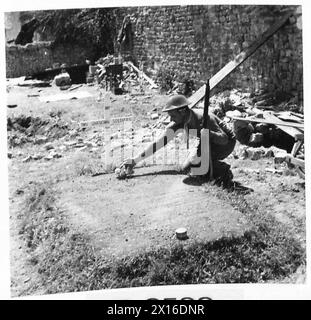 SCÈNES DANS LES RUINES DE TILLY SUR SEULLES - le soldat W. Sharp du 9th Durham Light Infantry, 20 Strensham Road, Birmingham, met la touche finale à une tombe de deux soldats inconnus de l'armée britannique, 21st Army Group Banque D'Images