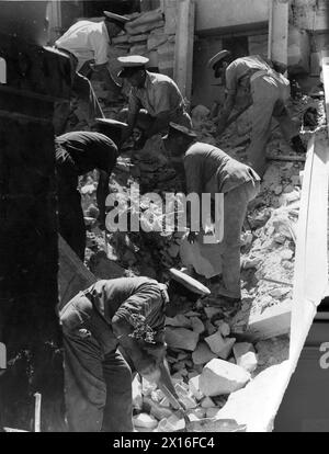 Des policiers aident à nettoyer les débris de l'Opéra endommagé par la bombe à la Valette, Malte, le 1er mai 1942. Banque D'Images