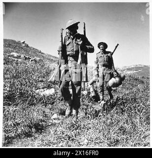 BATAILLE DE LA ROUTE OUED ZARGA MEDJEZ-El-BAB - de la zone autour de Chaouach vient la preuve du retrait hâtif de l'ennemi, ces deux Tommies viennent en charge de matériel allemand, fusils, casques en acier et respirateurs, etc Armée britannique Banque D'Images