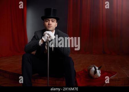 Showman en costume assis sur la scène de théâtre se reposant après le spectacle de magie Banque D'Images
