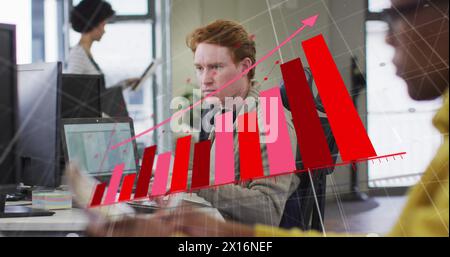 Image de graphiques financiers sur l'homme caucasien travaillant avec l'ordinateur dans le bureau Banque D'Images