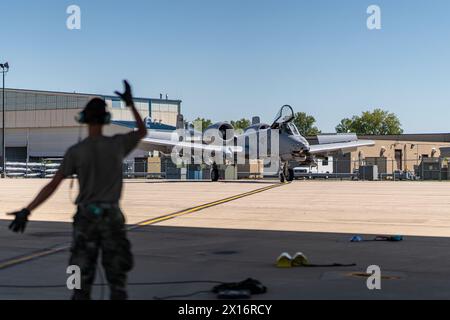 Un homme est debout sur la piste, faisant signe devant un avion de chasse. La scène est tendue et passionnante, alors que le chasseur se prépare au décollage Banque D'Images