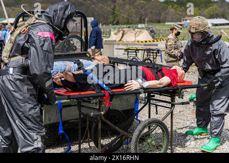 Un homme en costume de Hazmat aide à déplacer un homme sur une civière Banque D'Images