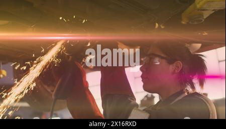 Image de lumière incandescente sur une femme biraciale travaillant dans un atelier de voiture. Petite entreprise, finance, informatique et concept de traitement des données généré numériquement Banque D'Images