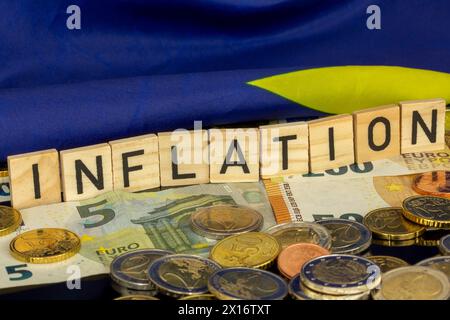 Image symbolique de l'inflation (dans la zone euro) : le mot INFLATION en cubes de lettres sur les pièces et billets en euros Banque D'Images