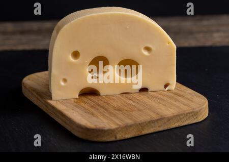 fromage à la crème avec des trous sur la table, fromage à pâte dure sur la table Banque D'Images