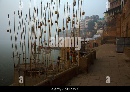 Paniers en osier suspendus à des poteaux de bambou sur la rive du Gange à Varanasi Banque D'Images