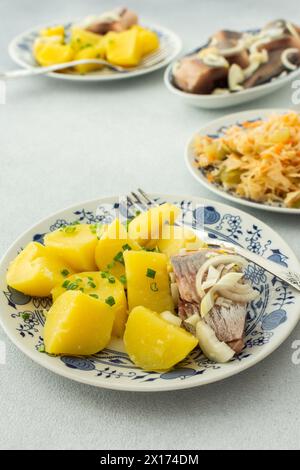 Délicieux dîners de poisson copieux, pommes de terre bouillies avec hareng mariné, choucroute avec oignons et huile d'olive Banque D'Images