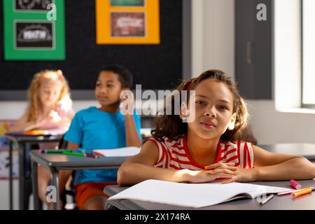 À l'école, groupe diversifié de jeunes étudiants se concentrant sur leur travail en classe Banque D'Images