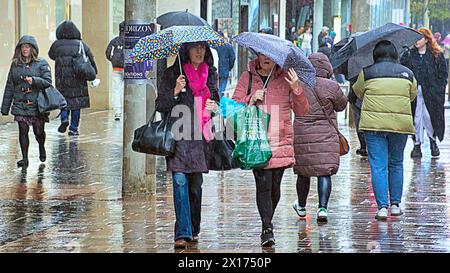 Glasgow, Écosse, Royaume-Uni. 15h avril 2024 : Météo britannique : humide et venteux dans la ville alors que les gens luttaient sur la capitale du shopping et le style mile de l'Écosse, Buchanan Street. Crédit Gerard Ferry/Alamy Live News Banque D'Images