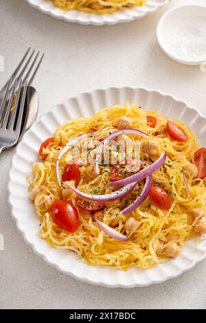 Courge spaghetti aux pois chiches et tomates garnie d'oignon rouge, faible teneur en glucides et idée de recette végétalienne Banque D'Images